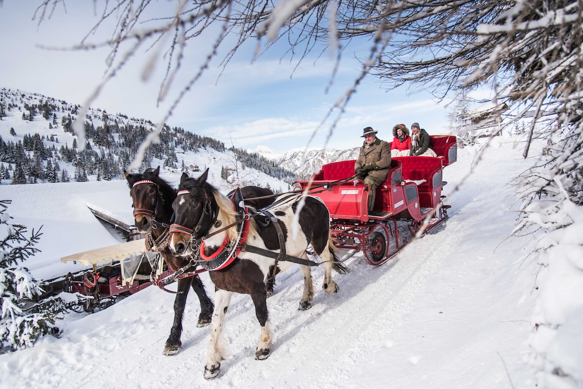 Eine Pferdeschlittenfahrt durch den tief verschneiten Winterwald - ein romantischer Start in den Winterurlaub.