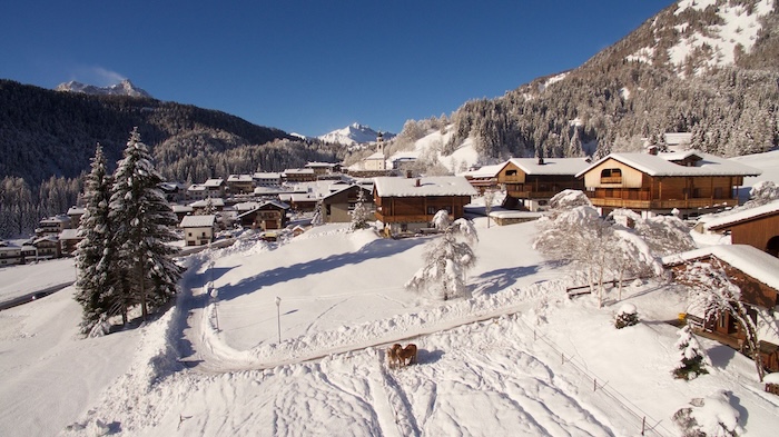 Herrlicher Blick auf das verschneite Sauris di Sotto mit seinen typischen Häusern aus Holz und Stein.